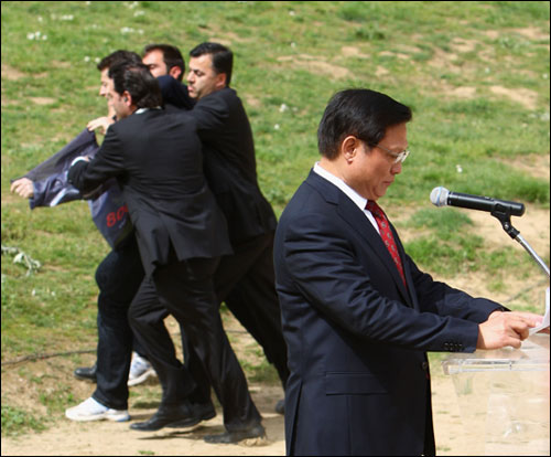 闹事者被希腊警察制服，并被带离现场，北京奥组委主席刘淇继续沉稳庄严地发表讲话。.jpg