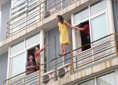 一位好心大妈拉住了女子的手，但女子挣脱后，从楼上跳下