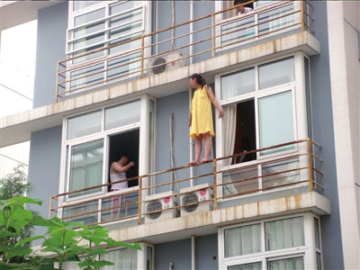 女子站在栏杆上欲跳楼