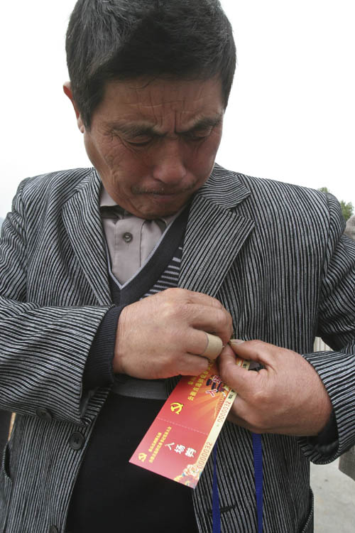 选举前，党员在胸前带上党徽